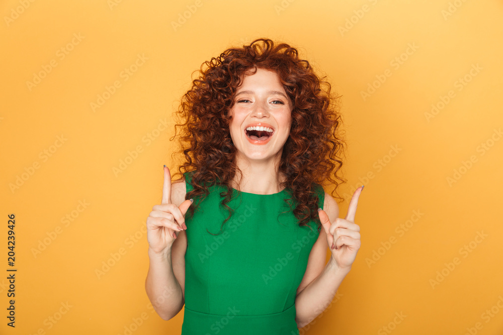 Portrait of a smiling curly redhead woman poinitng Portrait of a smiling curly redhead woman poinitng