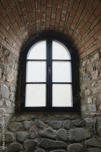 Arched window on the wall of the medieval fortress