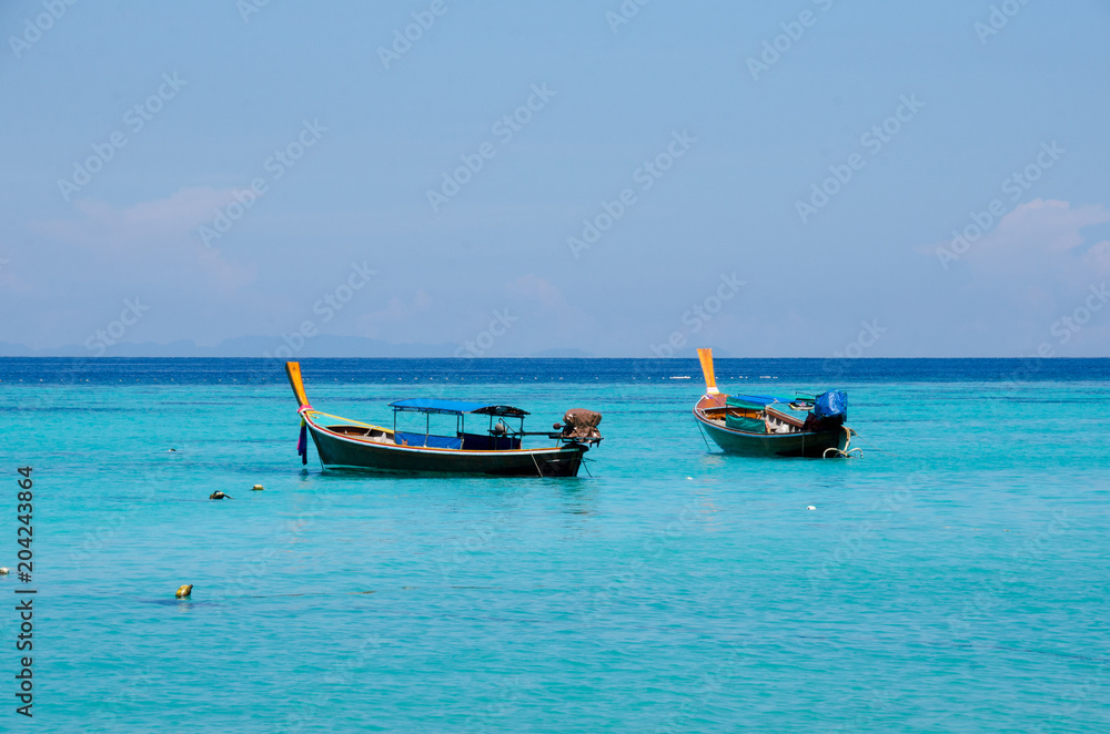Turquoise sea And blue sky White Sand Beach with two taxi long tail boat, travel concept. Koh Lipe, Satun, Thailand Turquoise sea And blue sky White Sand Beach with two taxi long tail boat, travel concept. Koh Lipe, Satun, Thailand