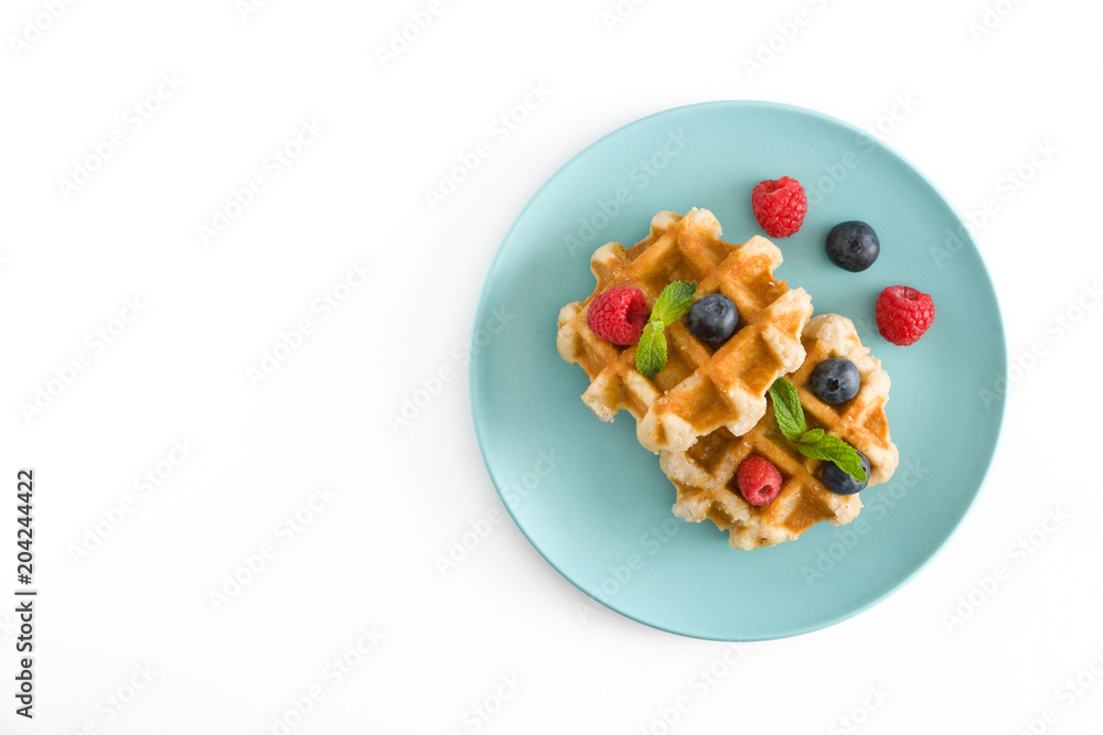 Traditional belgian waffles with blueberries and raspberries, isolated on white background. Top view. Copyspace
Traditional belgian waffles with blueberries and raspberries, isolated on white background. Top view. Copyspace
