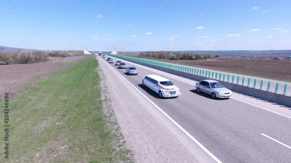 Aerial view of the cars passing on the road, wedding motorcade rides on the road, the quadcopter flies over the road HD Aerial view of the cars passing on the road, wedding motorcade rides on the road, the quadcopter flies over the road HD