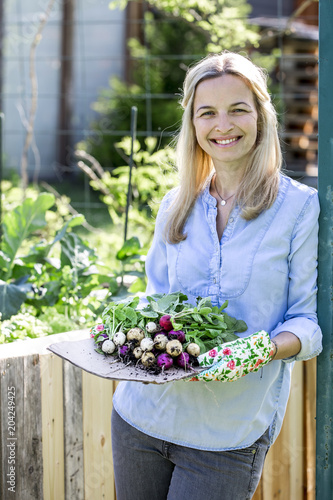 Woman is holding fresh bio radishes in her hands