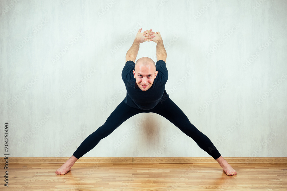 young and athletic man practices yoga and performs asanas in the gym young and athletic man practices yoga and performs asanas in the gym