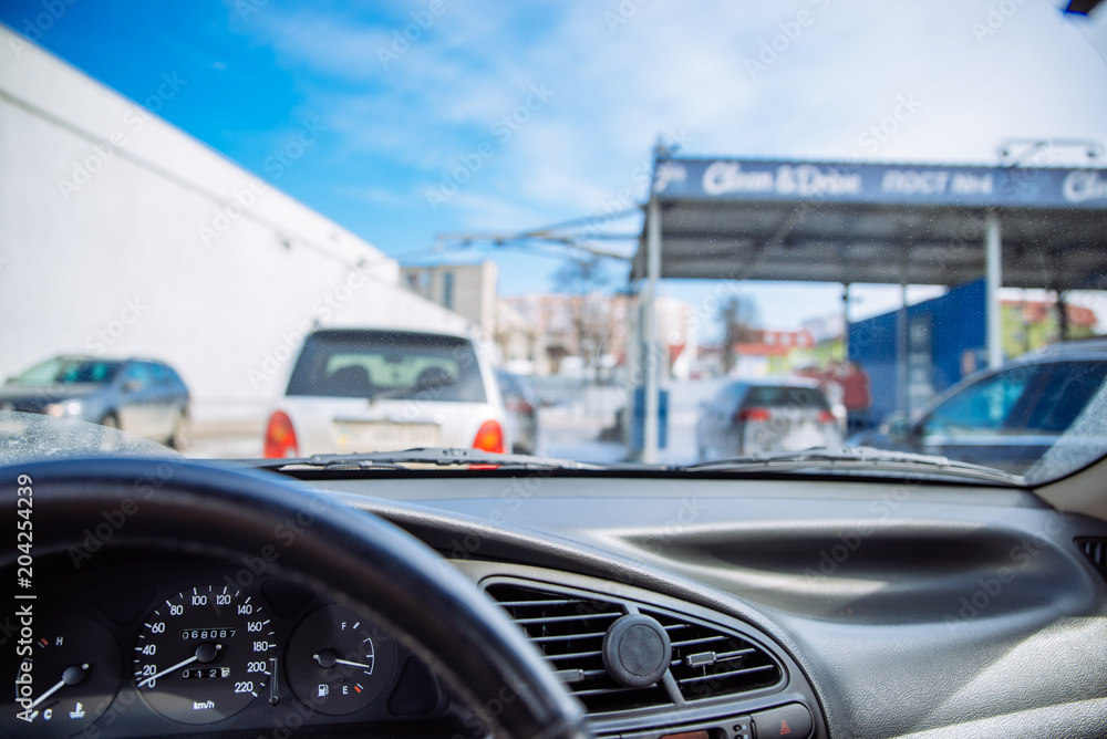 car line in car wash. time to clean auto. view from inside