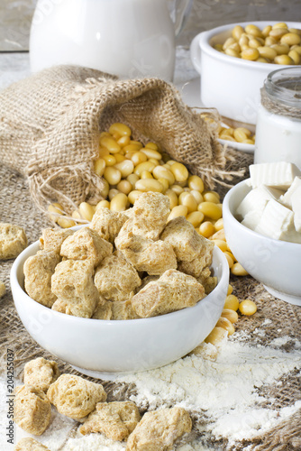 Ecological texturized soy meat with soy beans and tofu on rustic background photo