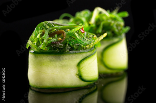 green gunkan maki - sushi on the black background