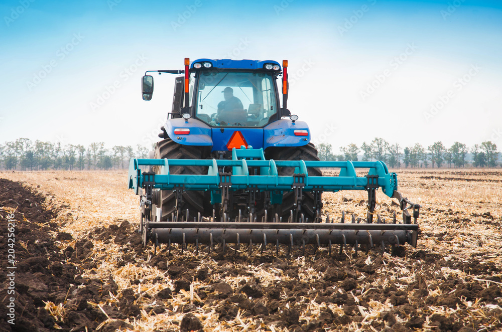 Fototapeta premium Modern tractor in the field on a sunny day.