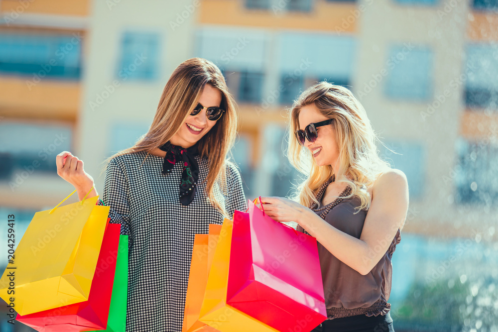 Happy friends shopping. Young friends enjoying shopping in the city, holding shopping bags. Happy friends shopping. Young friends enjoying shopping in the city, holding shopping bags.