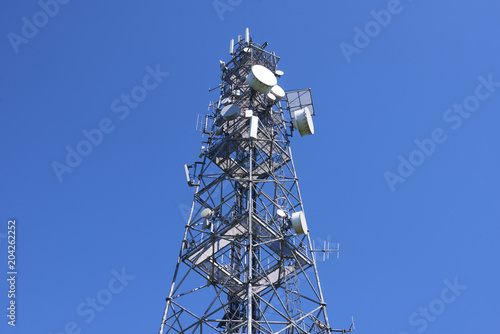  Telecommunication tower with antennas against the blue sky
