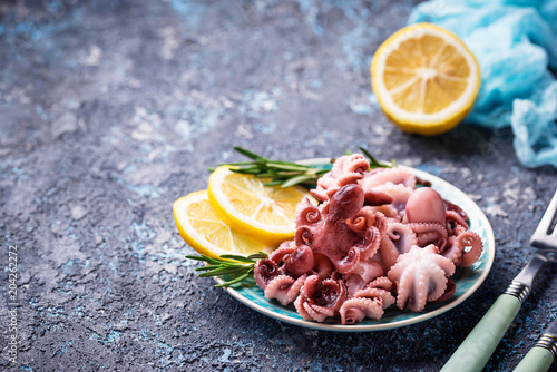 Baby octopus in plate with lemon and rosemary