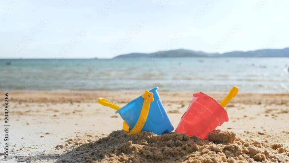 Toys on the sand beach with sea wave select focus shallow depth of field with summer atmosphere Toys on the sand beach with sea wave select focus shallow depth of field with summer atmosphere