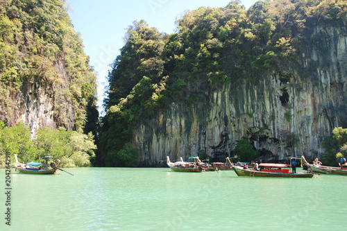 A beautiful blue and green lagoon with thai traditional long tail boats