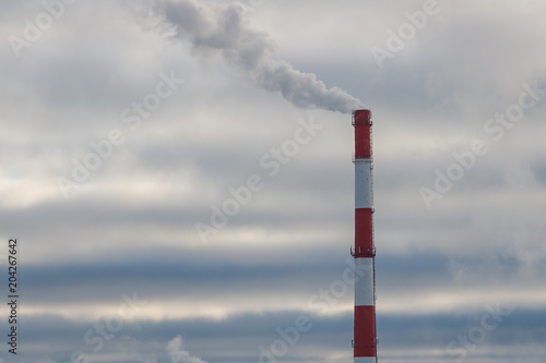 smoke from the pipe at the factory on the background of dark clouds