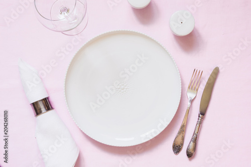 Table place setting on pink linen tablecloth. Top view. Concept.