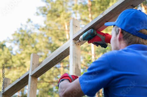 construction worker working on wooden house structure
