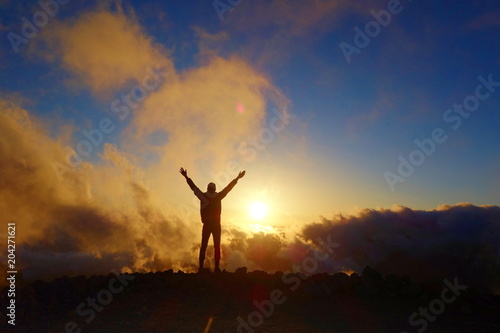 Colorful sunset with a silhouette of a relaxed teenage boy on a long distance hiking trail GR131 leading from Fuencaliente to Tazacorte, La Palma, Canary Islands, Spain photo