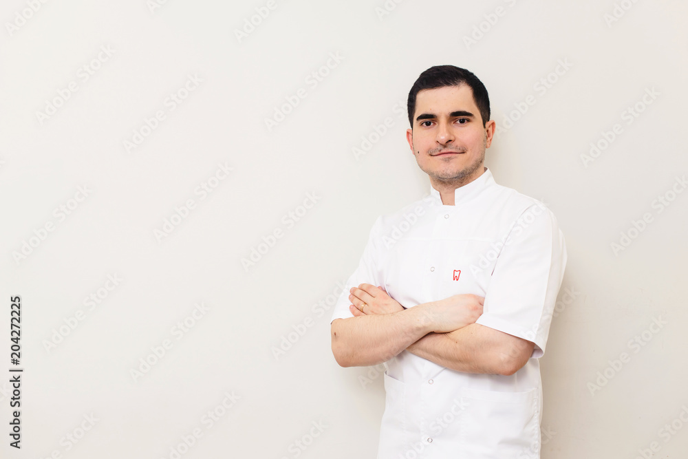 A portrait of a medical dentist doctor smiling and posing against white background isolated A portrait of a medical dentist doctor smiling and posing against white background isolated