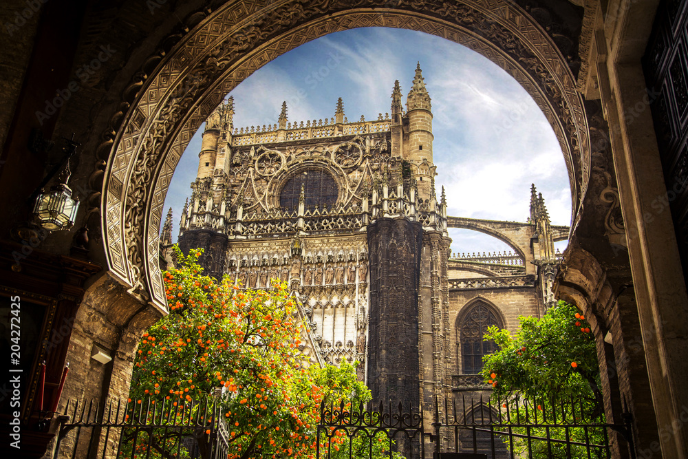 Fototapeta premium Seville Cathedral, Giralda tower, Sevilla, Spain. Church in Sevilla and orange trees