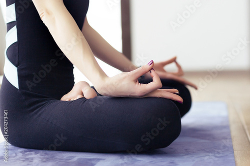 Woman meditating at home while practicing yoga lotus position