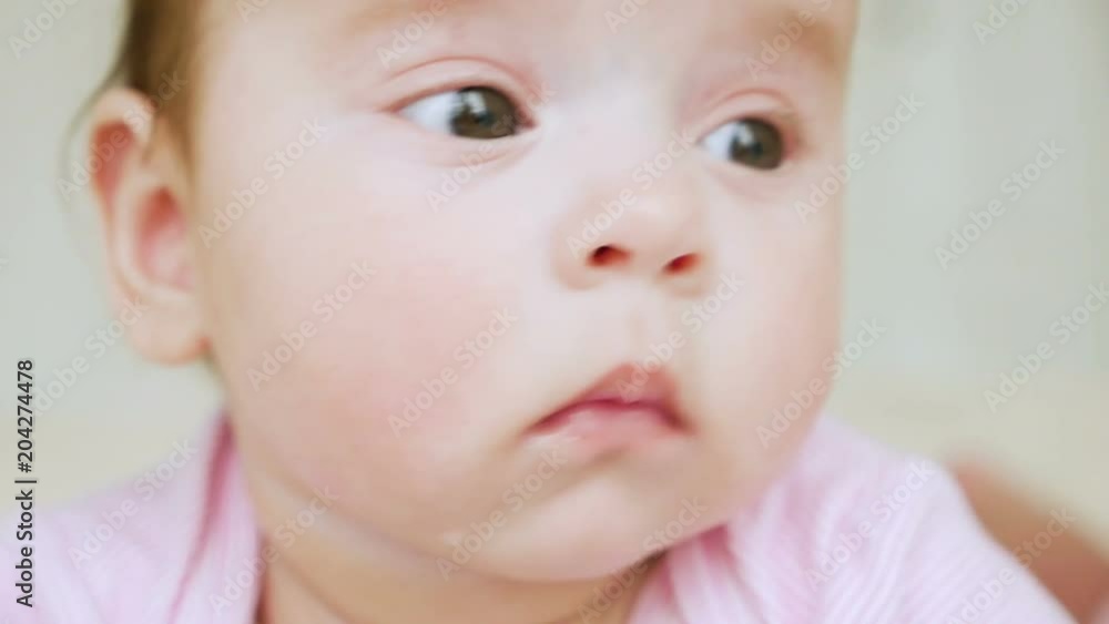 baby girl in pink clothes lying on her on his stomach on a diaper in bed baby girl in pink clothes lying on her on his stomach on a diaper in bed