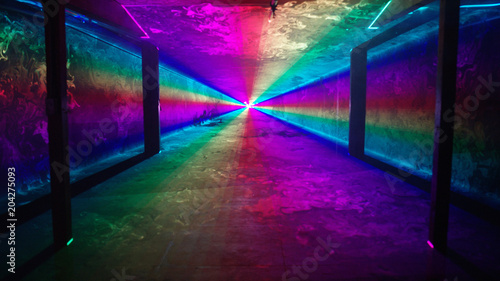 Rainbow laser light tunnel shines past columns at nightclub, background 3