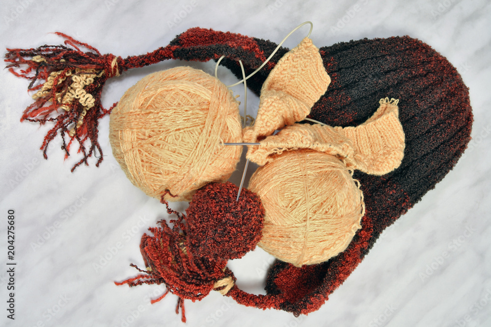 Hand-knitting.Finished product and balls of woolen threads