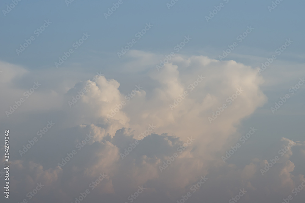 Beautiful fluffy white clouds in the light of the setting sun, background. Beautiful fluffy white clouds in the light of the setting sun, background.