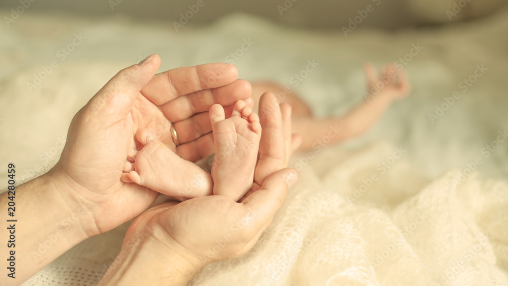 .happy mother hugging the legs of a newborn baby. .happy mother hugging the legs of a newborn baby.