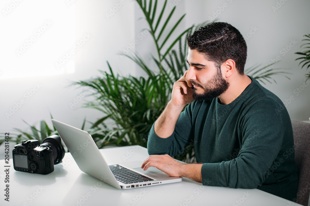 young man using his mobile and working in his office. business concept young man using his mobile and working in his office. business concept