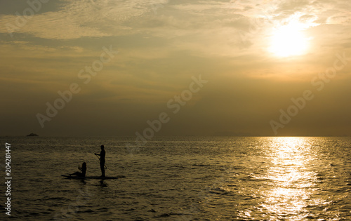 Silhouette of a couple on paddle board on the open sea at sunset in the island of Koh Pha Ngan, Thailand © Josu Ozkaritz