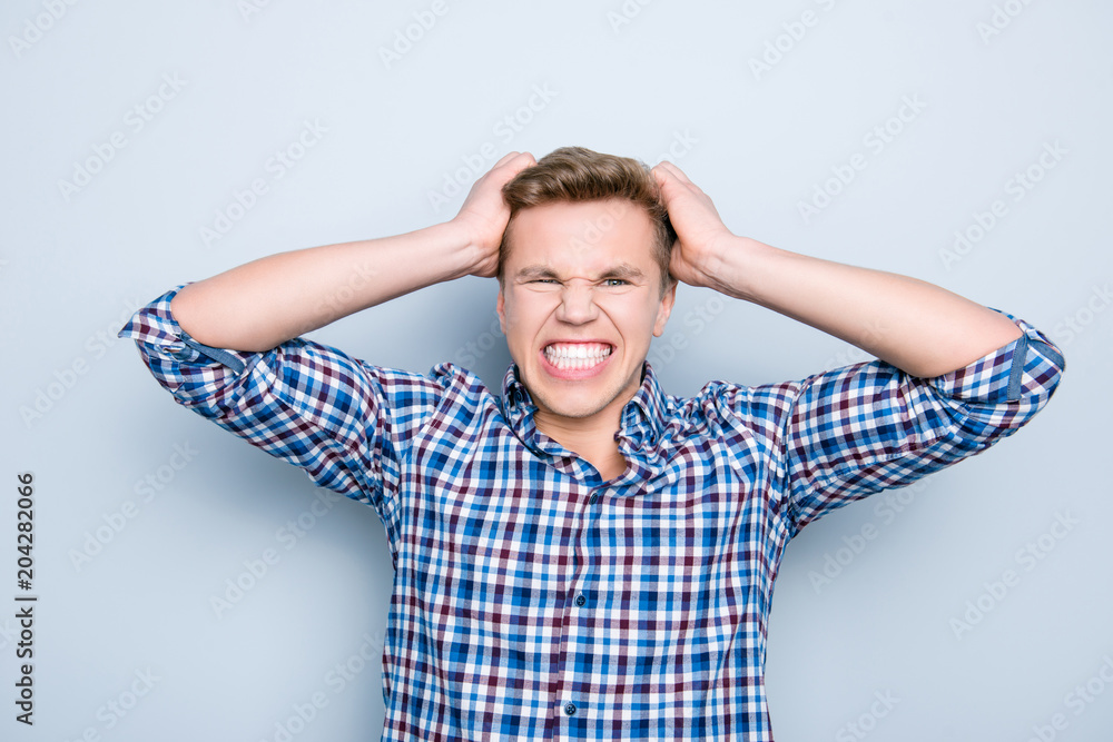 Portrait of sad upset troubled unlucky mad grimacing frustrated exhausted specialist trainee business freelancer pulling out his hair wearing casual clothes outfit isolated on gray background Portrait of sad upset troubled unlucky mad grimacing frustrated exhausted specialist trainee business freelancer pulling out his hair wearing casual clothes outfit isolated on gray background