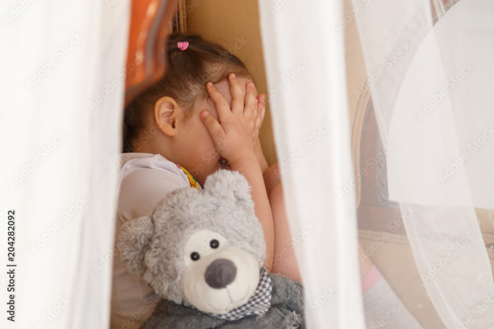 Little kid hiding behind teddy bear Little kid hiding behind teddy bear