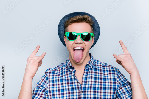 Heavy metal listen music lover concert modern people person fan mad concept. Close up portrait of excited cheerful crazy rejoicing delightful guy demonstrating tongue out isolated on gray background