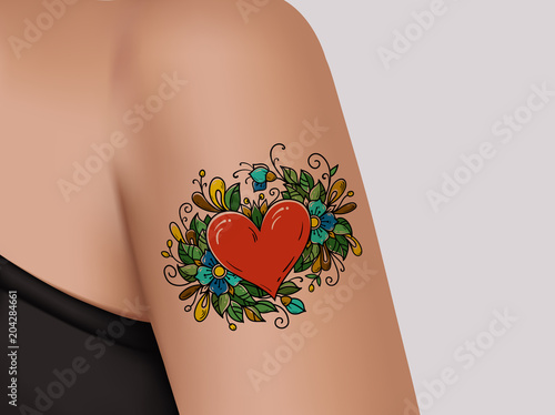Tattoo on shoulder. Heart decorated with flowers