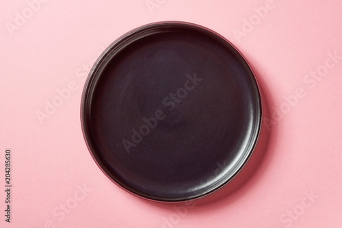 Black plate on pink background, from above