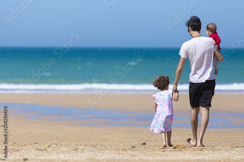 Dad and daughters in the beach