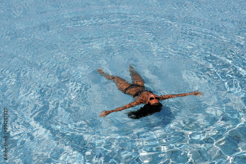 Junge Frau im Bikini treibt auf dem Wasser