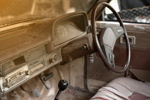Old car interior with the steering wheel and dashboard.