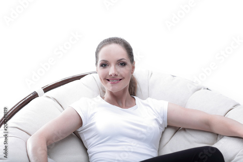 young woman resting in a circular chair with rattan