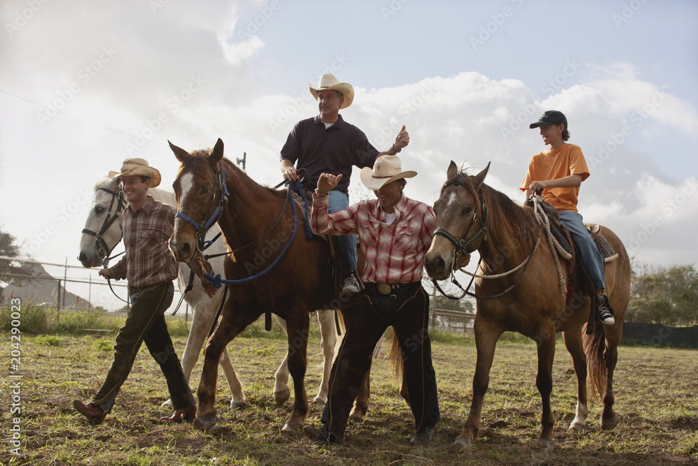 Men walking through field with horses Men walking through field with horses