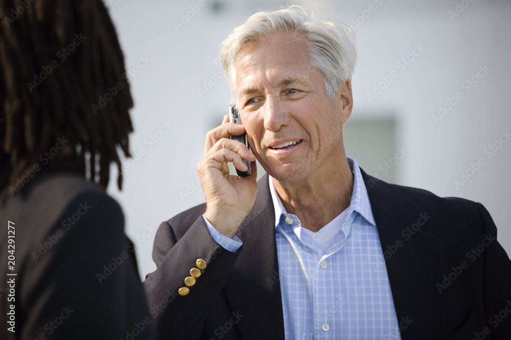 Mature businessman talking on a cell phone. Mature businessman talking on a cell phone.