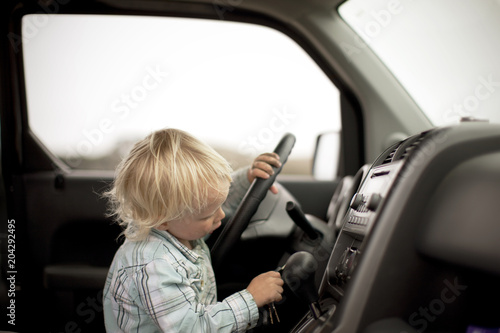 Curious boy trying to insert keys into the ignition of car