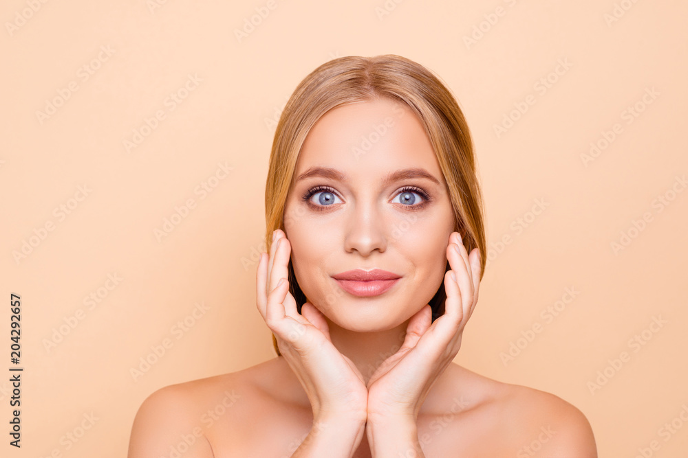 Big eyed, charming, pretty, cute, lovely girl enjoying her perfect face skin after mask, lotion, peeling, cream, balm, holding hands on cheek, isolated on beige background, wellness wellbeing concept Big eyed, charming, pretty, cute, lovely girl enjoying her perfect face skin after mask, lotion, peeling, cream, balm, holding hands on cheek, isolated on beige background, wellness wellbeing concept
