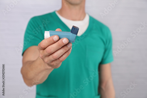 Doctor giving an asthma inhaler to the patient close up