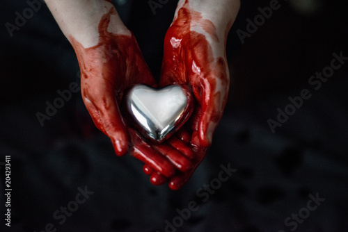 Bloody Hands Holding A Silver Heart 