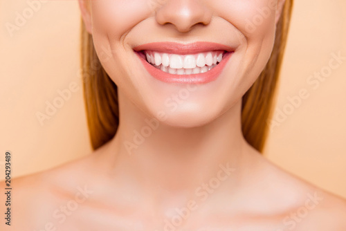 Close up cropped half face portrait of attractive, nude, natural, perfect, ideal girl with healthy white teeth isolated on beige background, perfection, wellness, wellbeing, restoration concept