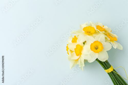 Fototapeta Naklejka Na Ścianę i Meble -  Spring flowers daffodil bouquet - top view of white narcissus on blue pastel background with copy space.