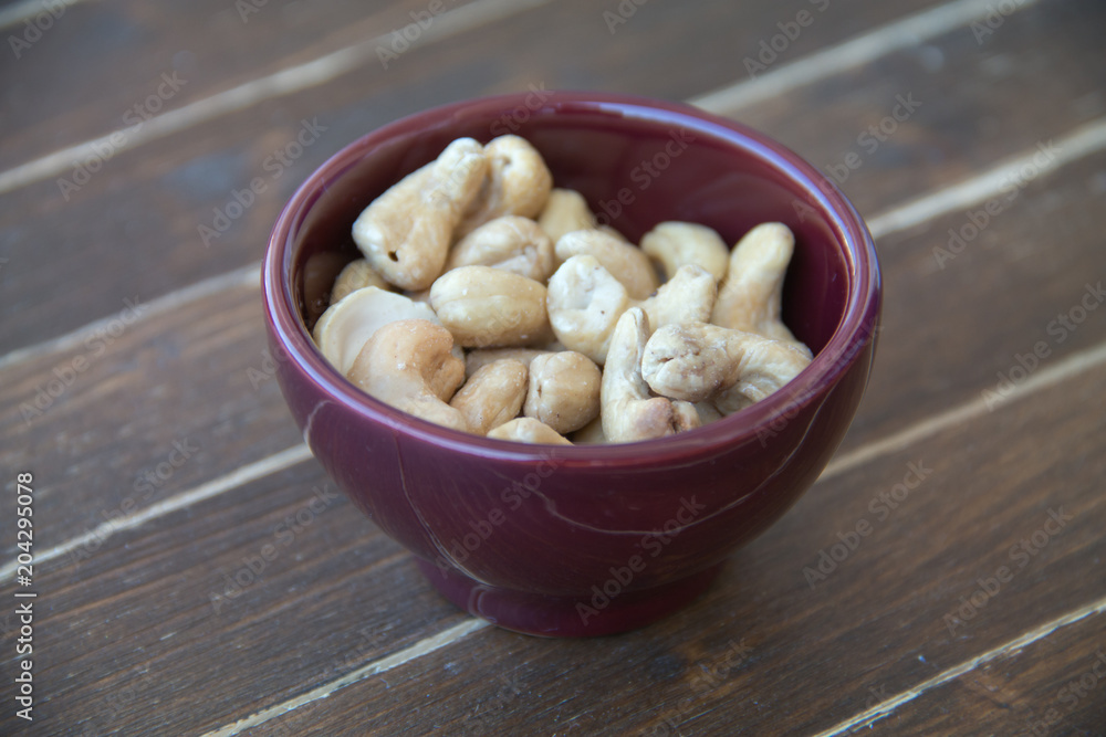 cashew nuts inside bowl on a wooden table seen close up cashew nuts inside bowl on a wooden table seen close up