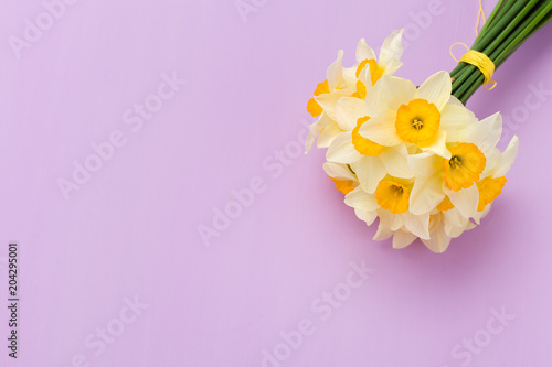 Fototapeta Naklejka Na Ścianę i Meble -  White daffodil bouquet on violet pastel background with copy space.