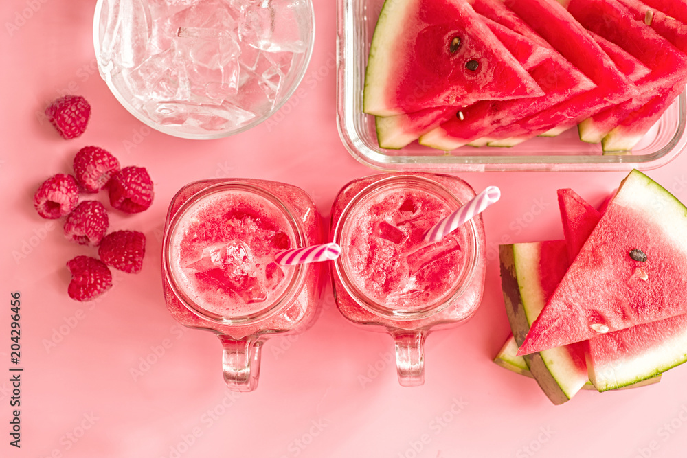 summer drinks concept. watermelon slices, ice cubes and smoothies in mason jar on pink fashion background top view. creative layout of watermelon and smoothies on pink top view summer drinks concept. watermelon slices, ice cubes and smoothies in mason jar on pink fashion background top view. creative layout of watermelon and smoothies on pink top view